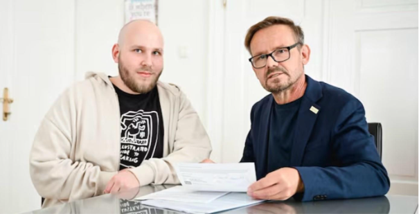 zwei Männer und einer hat Zettel in der Hand.